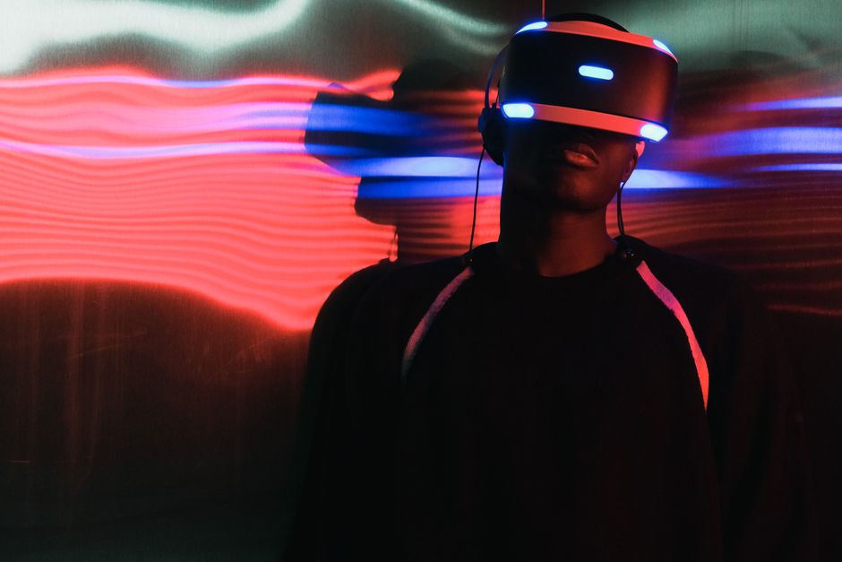 Persona con casco de realidad virtual rodeada de luces neón